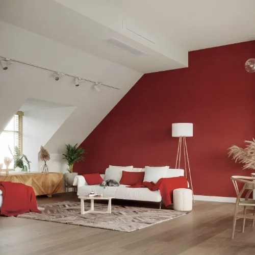 Pompe à chaleur air/air gainable diffusant l’air par une bouche encastrée au plafond d’un salon